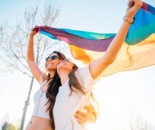 Dos chicas con la bandera LGTBI